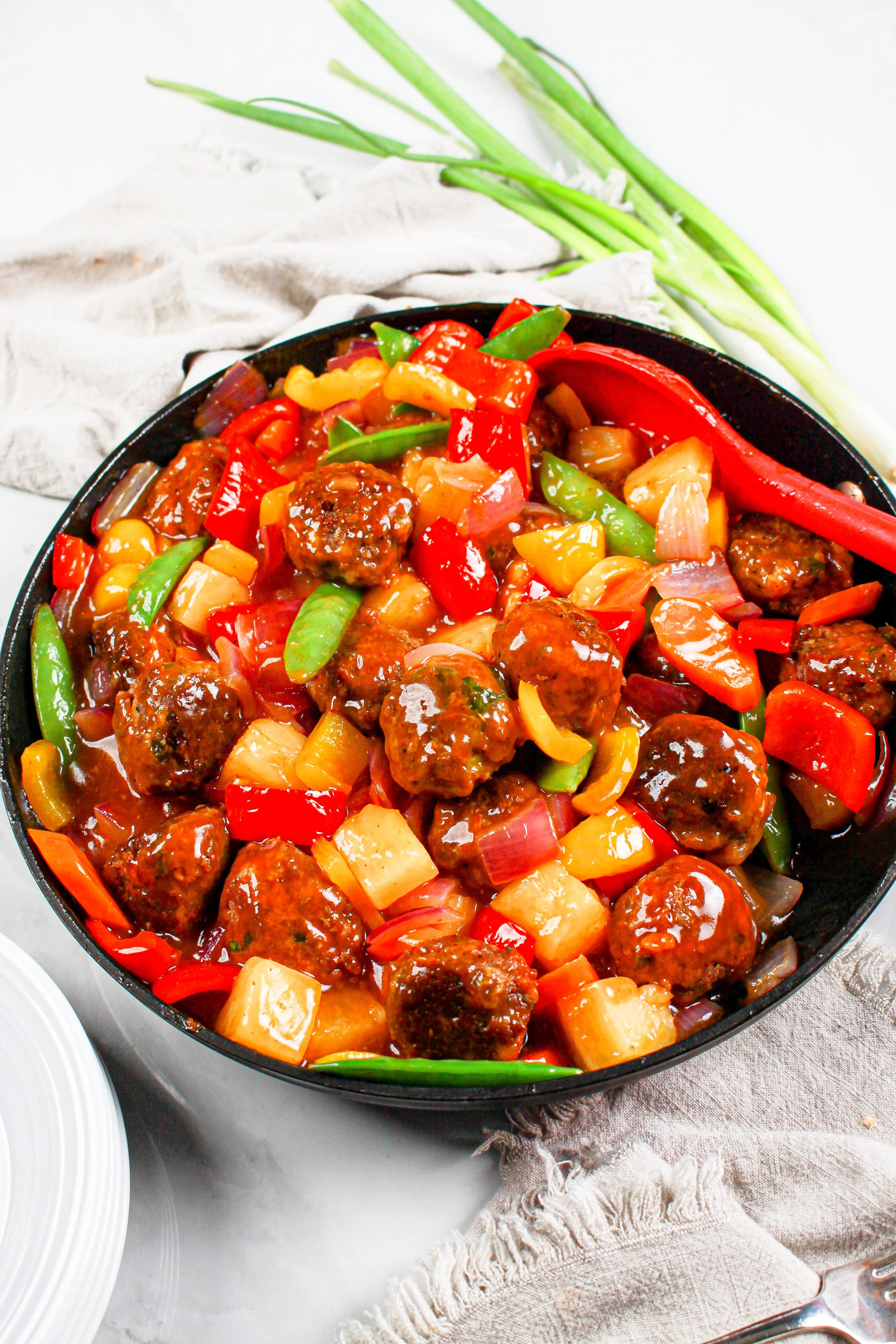 Plant based meatballs in sweet and sour sauce with colorful vegetables
