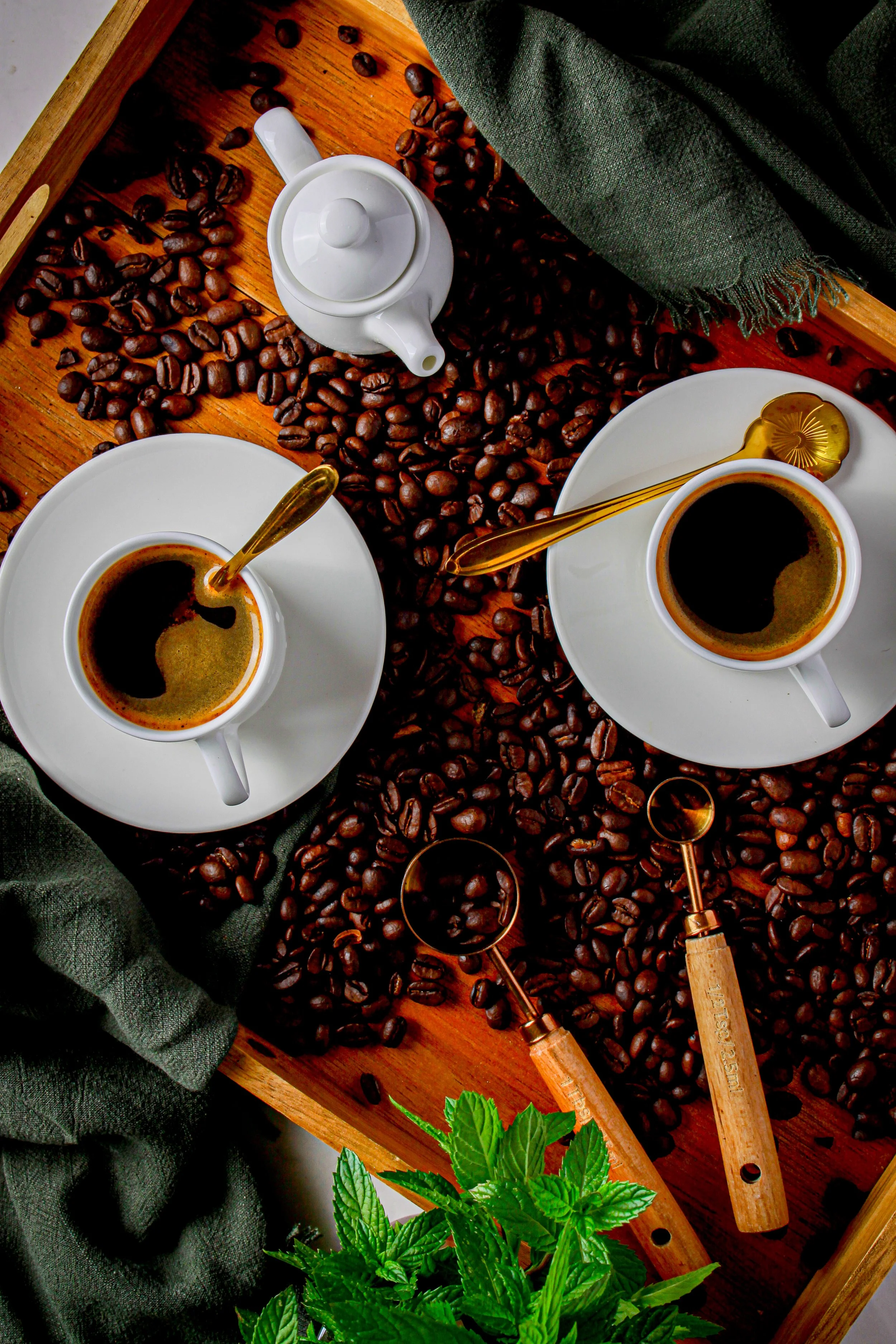 Top-down view of two white cups of black coffee on white saucers